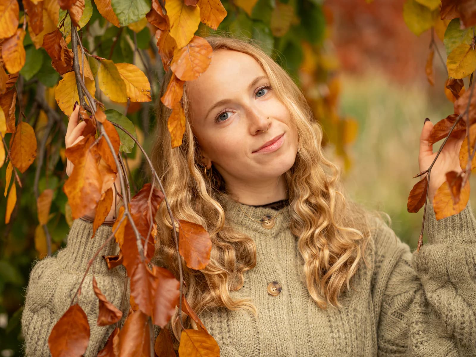 Herbstportrait von Lily zwischen orangefarbenen Blättern
